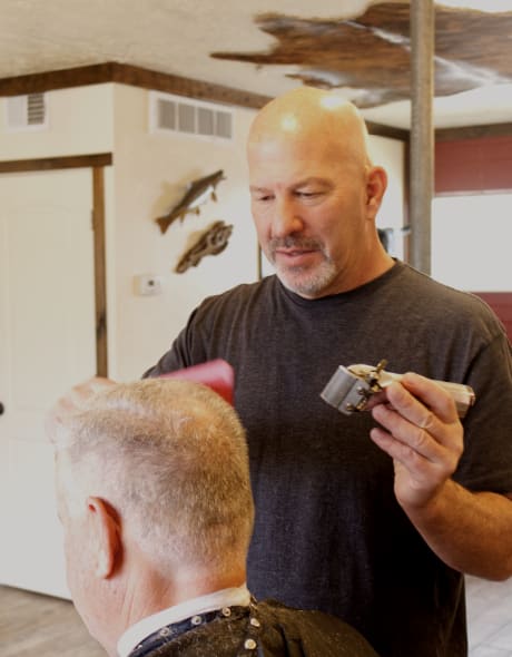 Barber trimming a customer's hair with clippers at Cook's Barbershop